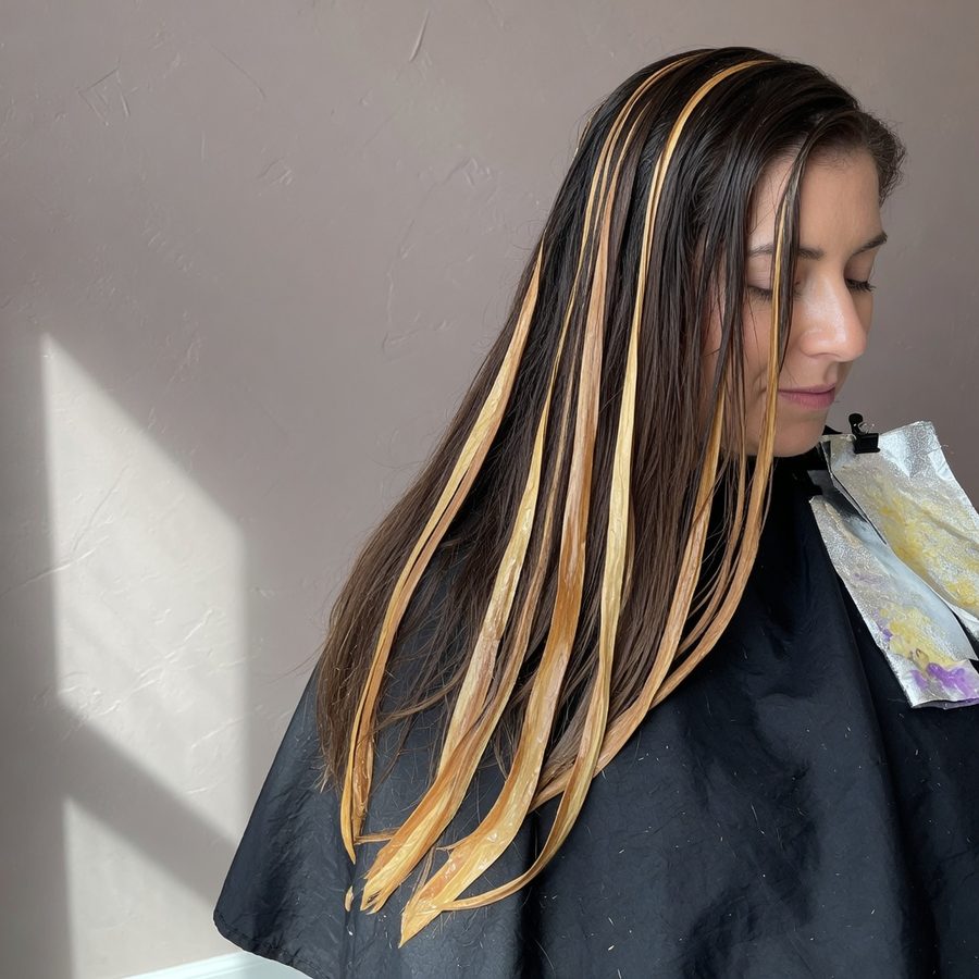 Balayage in process, honey ribbons through a brunette base