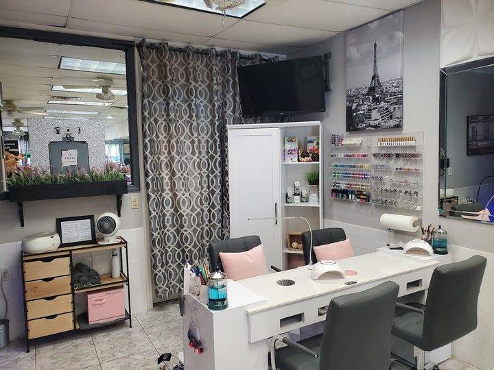 Nail station at Envy Salon with grey chairs and a Paris print