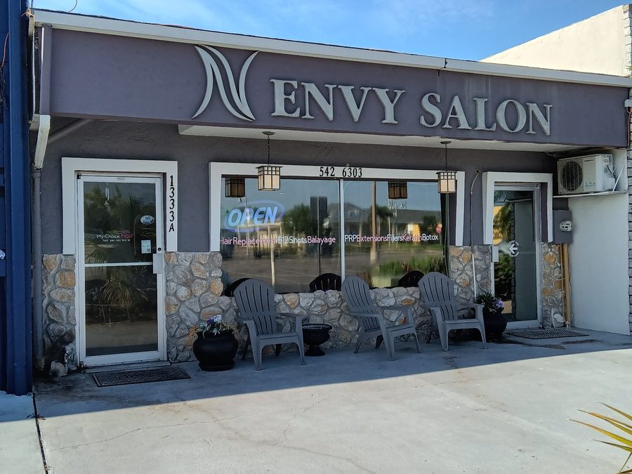 Envy Salon storefront on Cape Coral Parkway East, taupe fascia with silver letters and Adirondack chairs