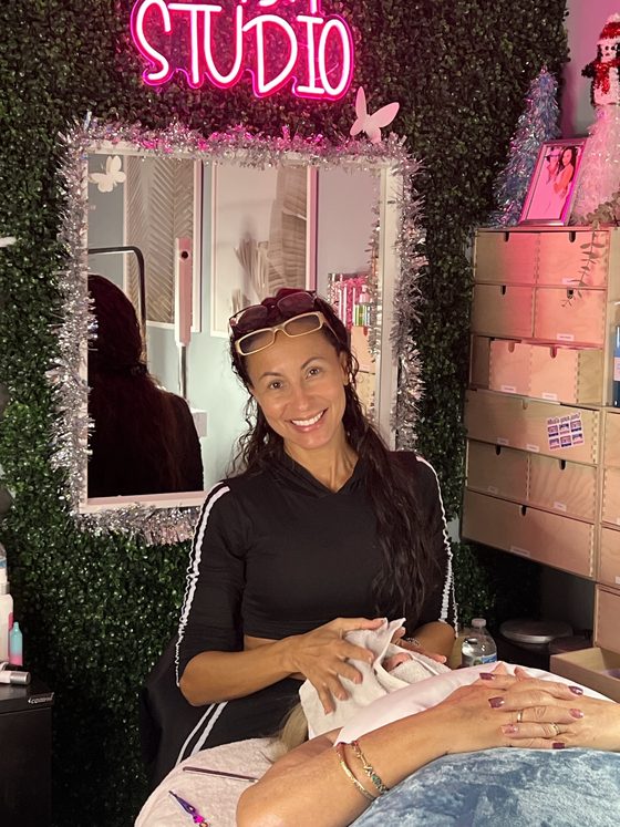 Skin studio at Envy Salon, pink neon over a hedge wall